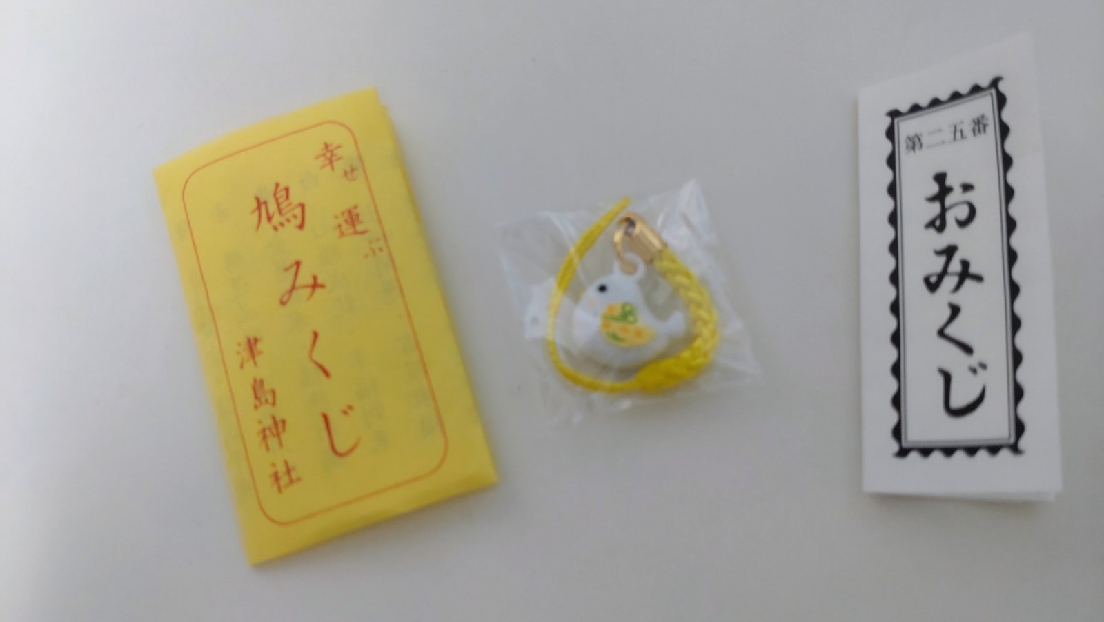 鳩みくじの袋とストラップとおみくじ